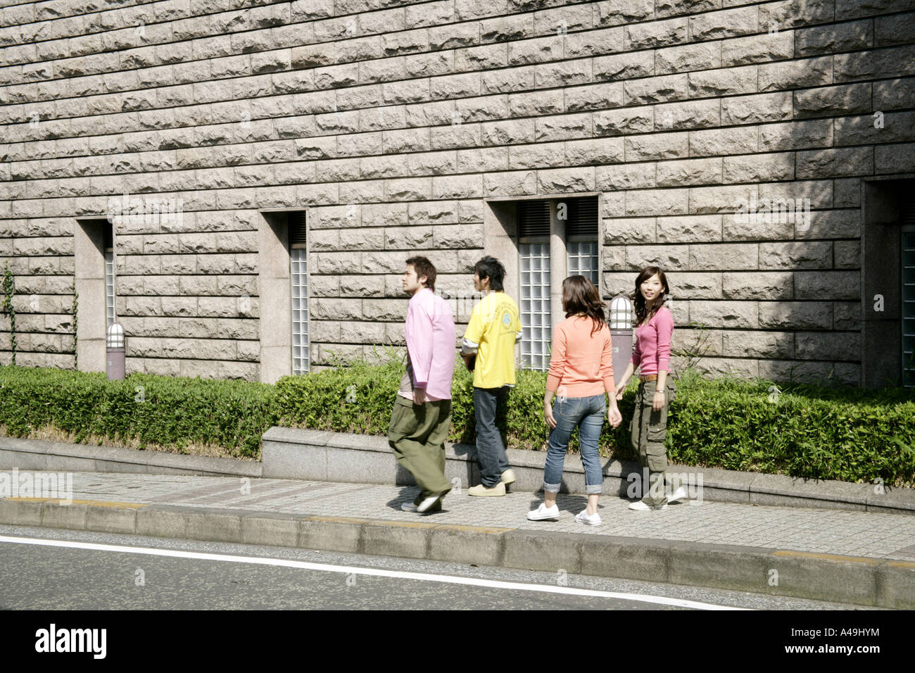 Two young women and two young men walking on a footpath Stock Photo - Alamy
