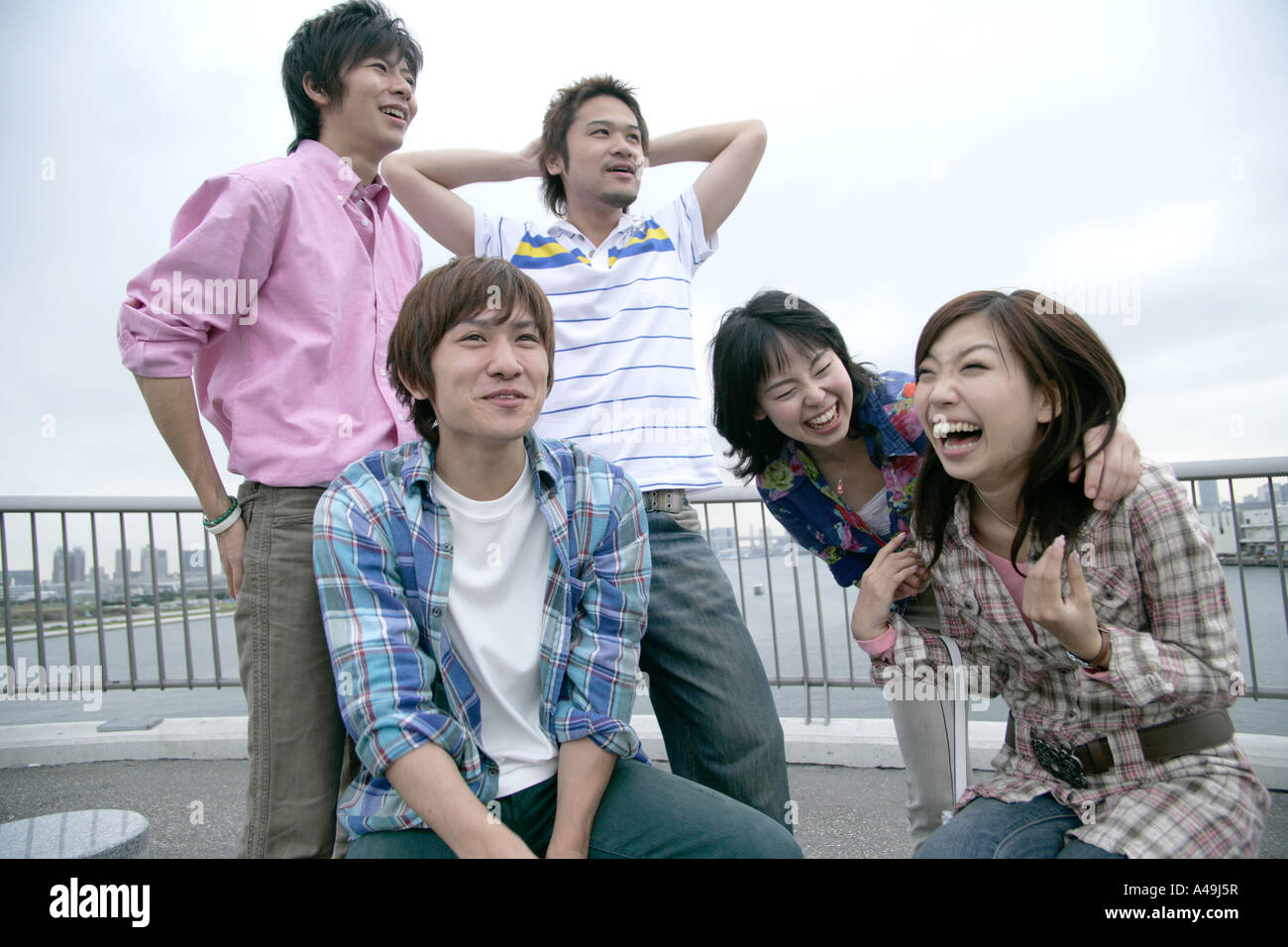 Three young men and two young women smiling Stock Photo - Alamy