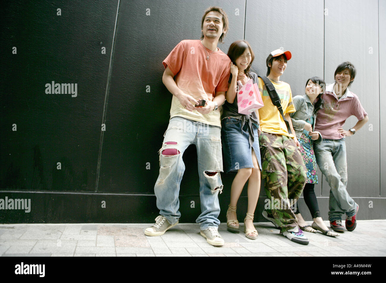 Two young women and three young men standing together Stock Photo - Alamy