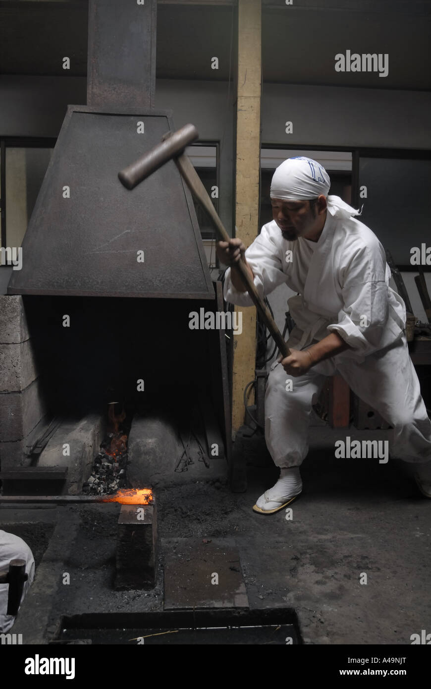Blacksmith hitting a heated metal rod with a hammer Stock Photo Alamy