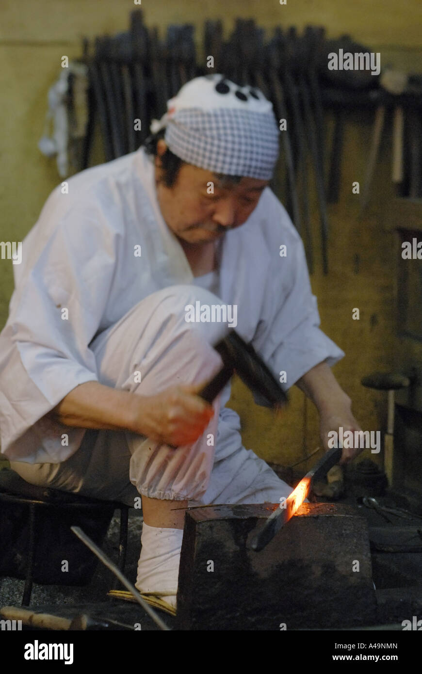 Blacksmith hitting a heated metal rod with a hammer Stock Photo Alamy