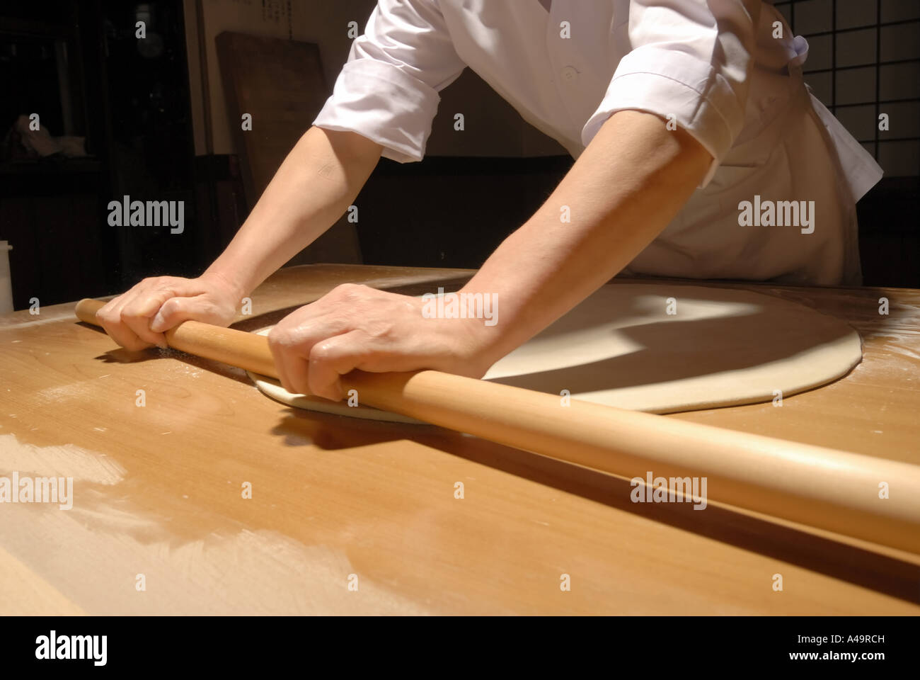 Mid section view of a chef rolling dough Stock Photo