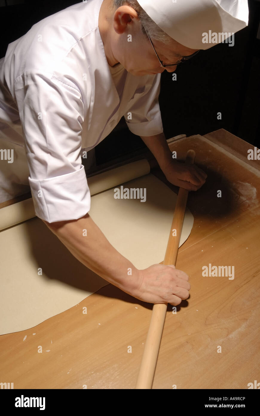 Close up of a chef rolling dough Stock Photo