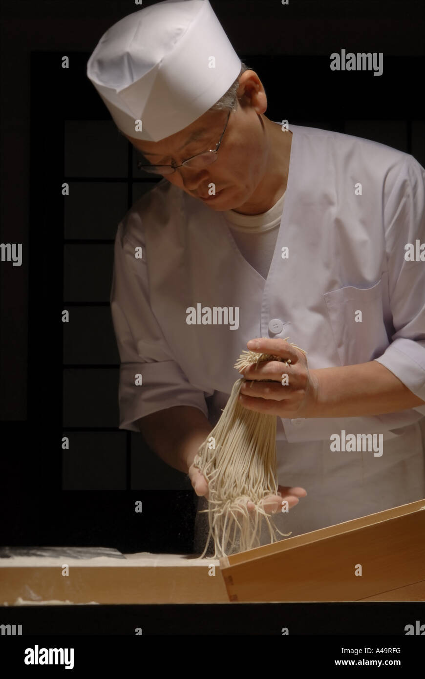Close up of a chef applying flour on raw noodles Stock Photo
