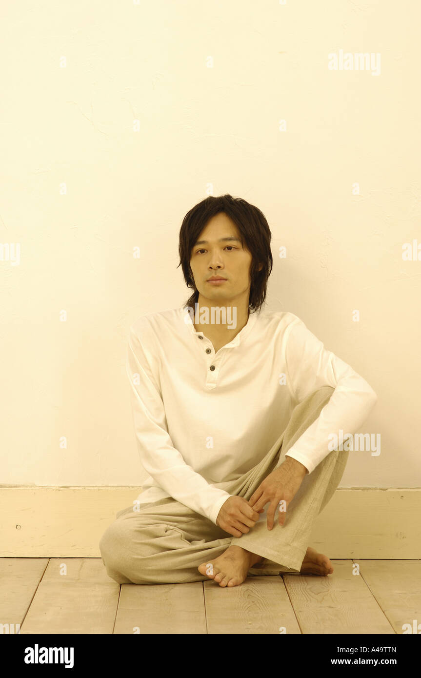 Young man sitting on the floor with his legs crossed Stock Photo - Alamy