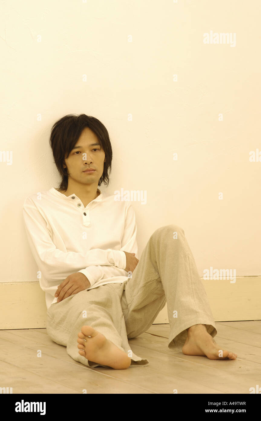 Young man leaning against a wall Stock Photo - Alamy