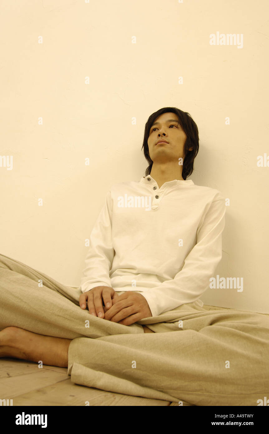 Young man sitting on the floor with his legs crossed Stock Photo - Alamy