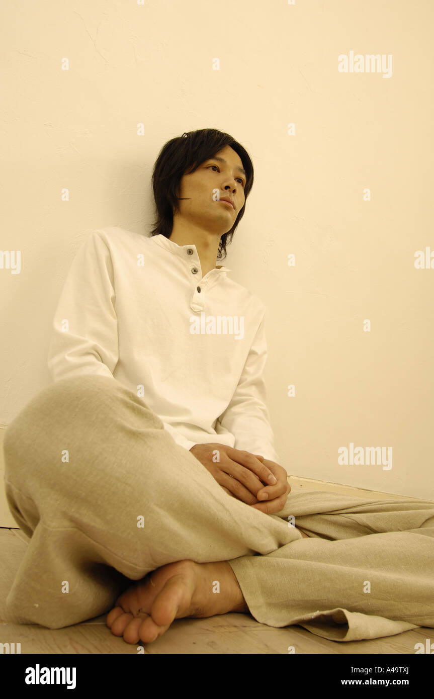 Young man leaning against a wall Stock Photo - Alamy