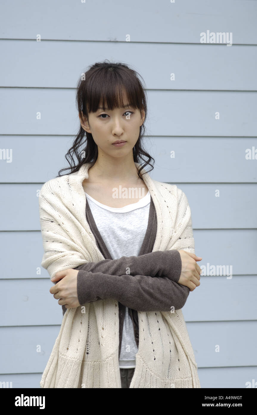 Portrait of a young woman standing with her arms crossed Stock Photo ...