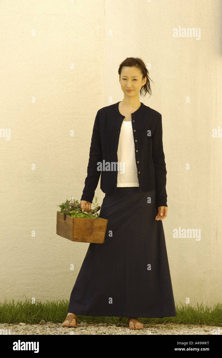 Portrait of a young woman holding a potted plant Stock Photo - Alamy
