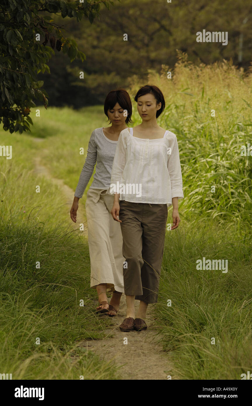 Two young women walking on a trail Stock Photo - Alamy