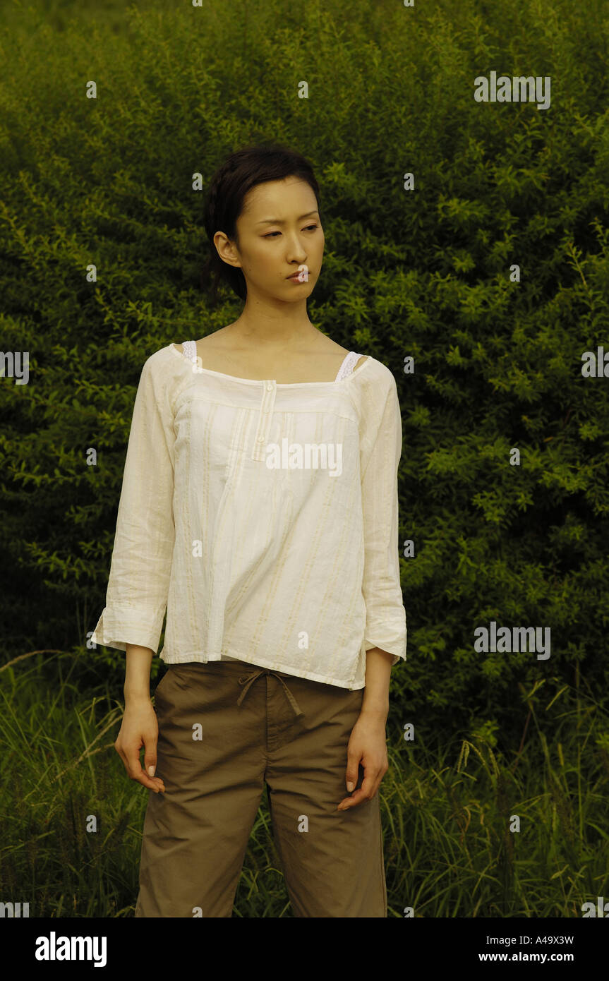 Young woman standing in a field Stock Photo - Alamy