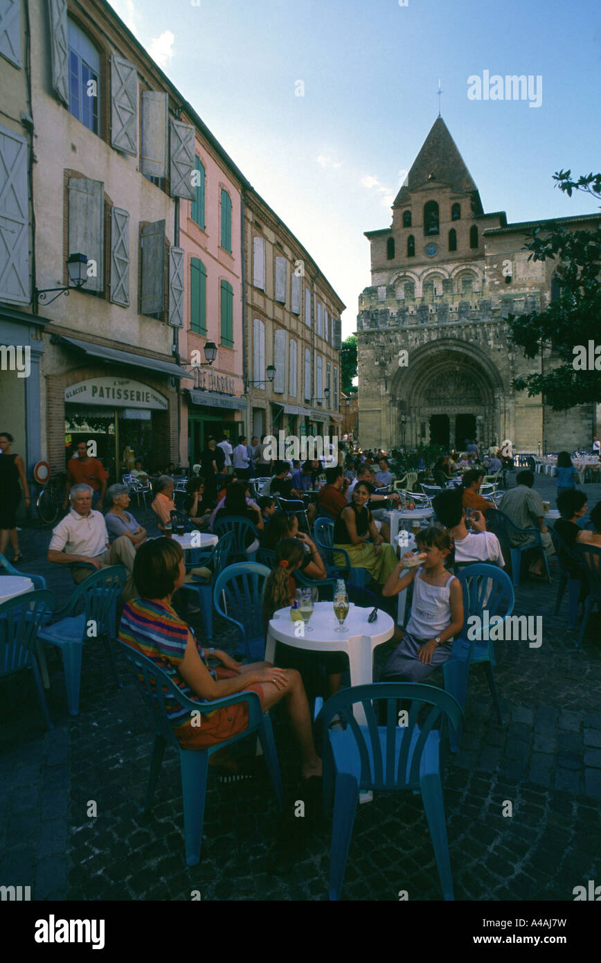 France. Moissac. Cafe customers sit in front of Abbey St. Pierre in the evening. Stock Photo
