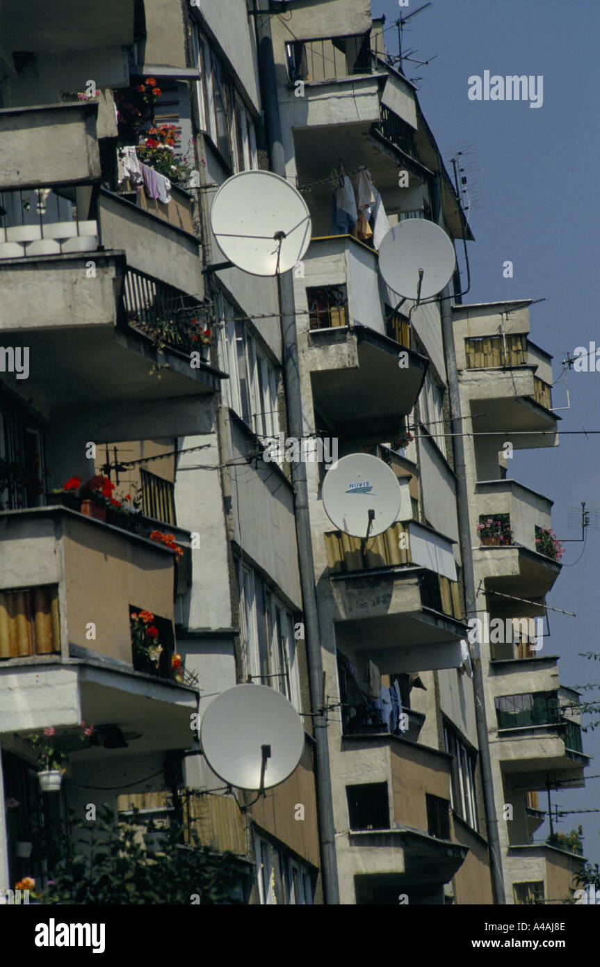 satellite dishes and tv aerials on balconies of apartment block in