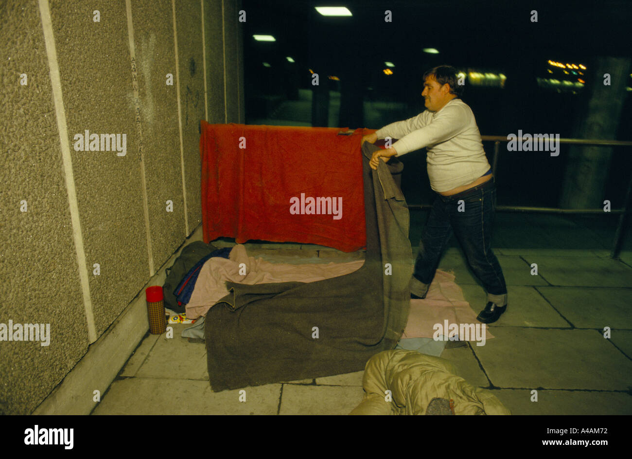 Homeless Man Preparing Bed Under Royal Festival Hall London Stock Photo