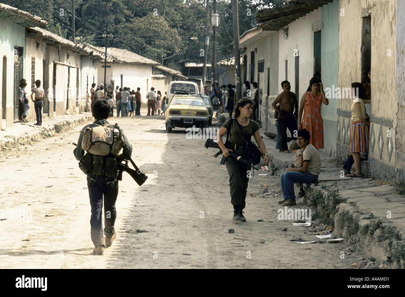 TENANCINGO,  EL SALVADOR, MARCH 1984: - Within the FPL Guerrilla's Zones of Control.  Guerrilla fighter in the streets of  Tenancingo while journalists take advantage of a windo of opportunity to visit the contested town. Stock Photo