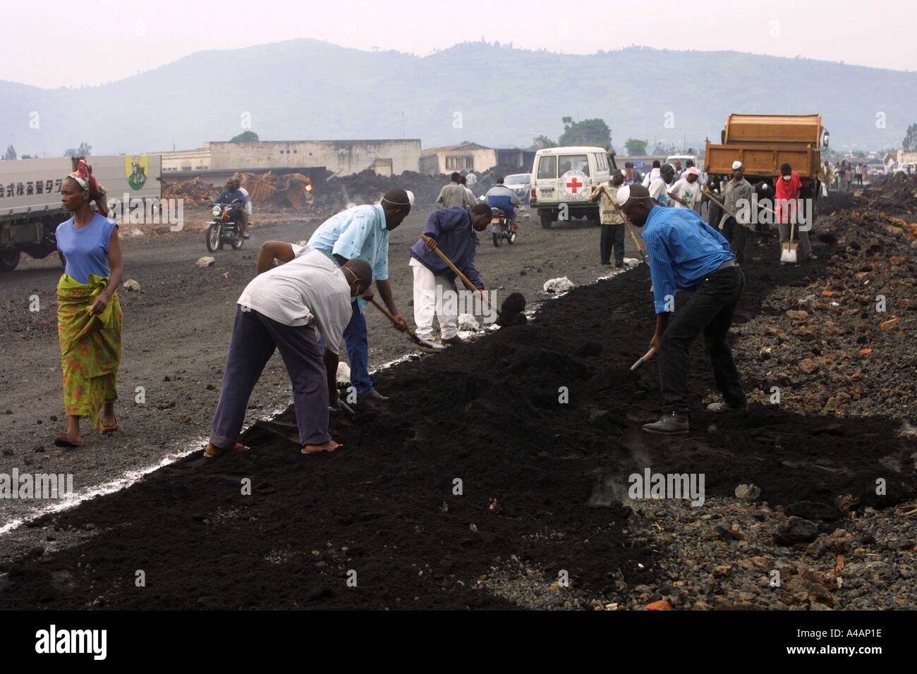 Jan 2002 Goma; Within one week of the volcanic eruption that devastated the town, workers are putting down lava gravel to create a pavement.  Jan 2002 Goma Stock Photo