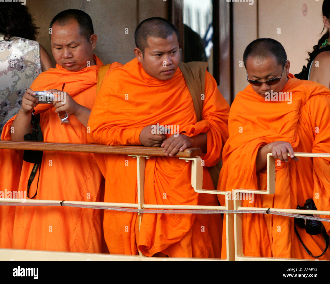 Buddhist monks wearing saffron robes with digital camera Stock Photo
