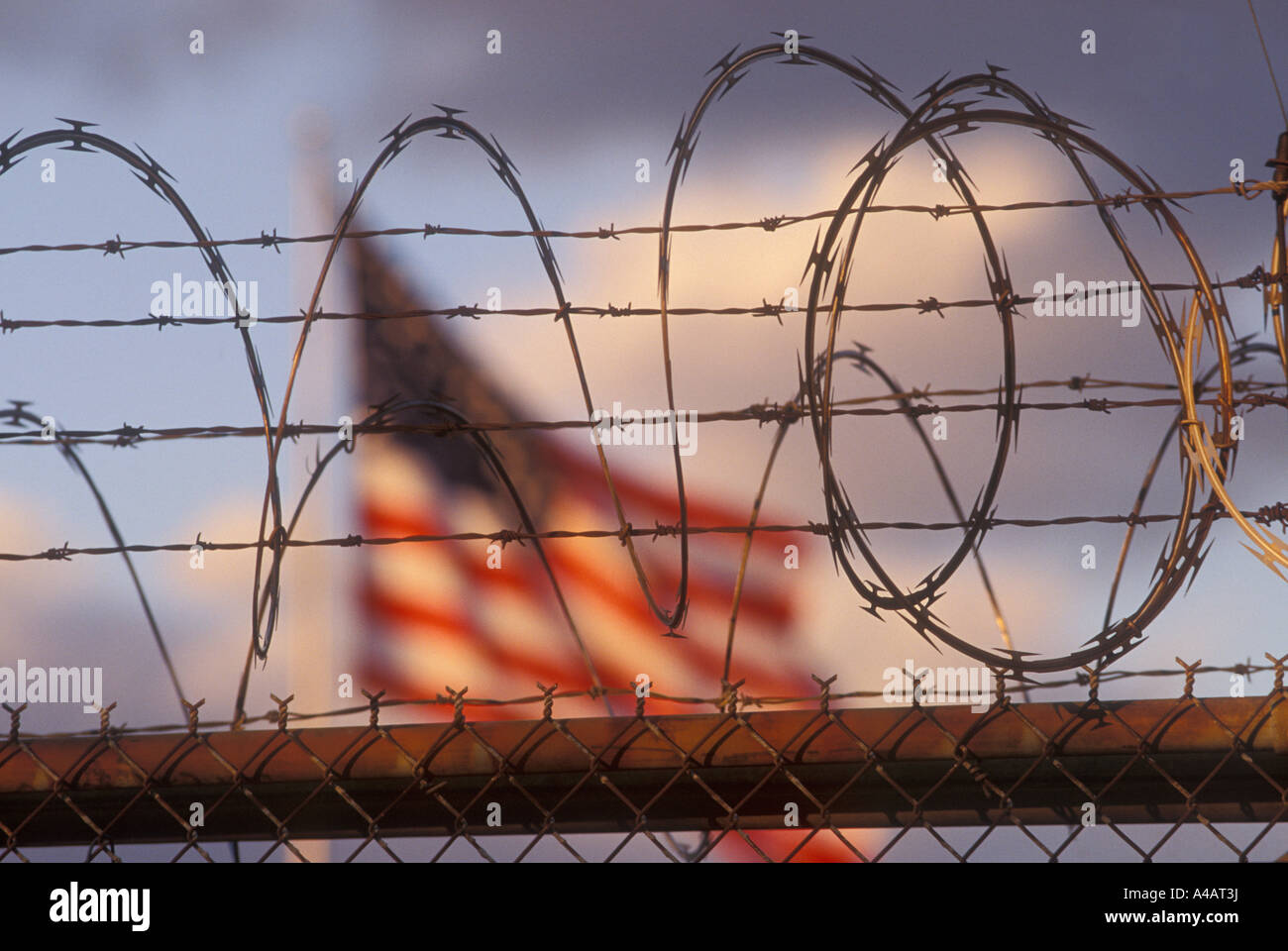 Detroit Michigan The American flag flies over a warehouse protected with razor wire Stock Photo