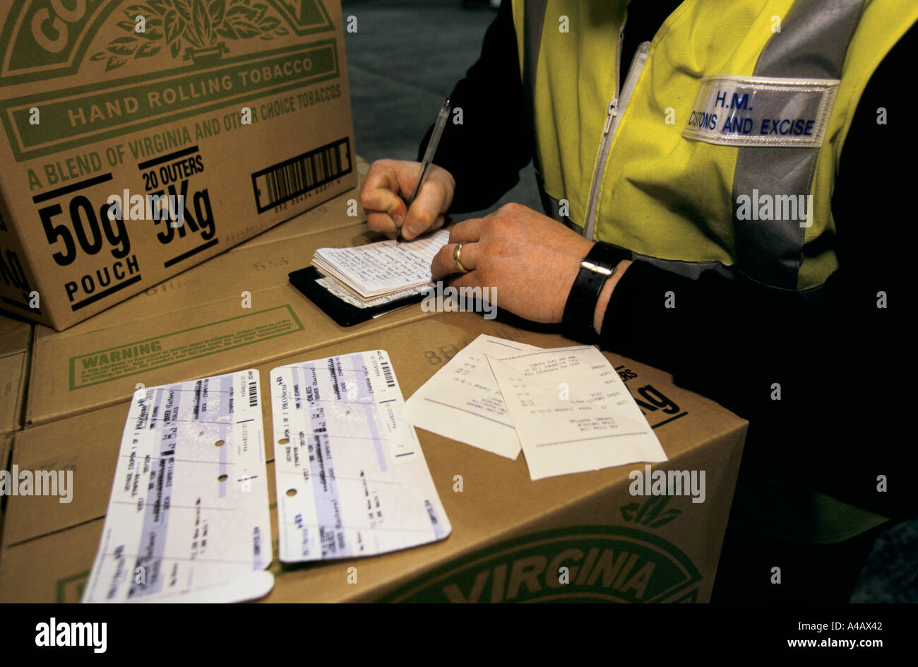 A CUSTOMS & EXCISE OFFICER AT  DOVER PORT ON ENGLAND'S SOUTH COAST CATALOGUES GOODS BEING CONFISCATED FROM A SMUGGLER. Stock Photo