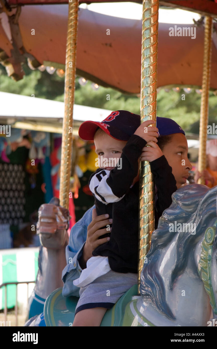 Little Boy riding the carousel at the carnival Stock Photo - Alamy
