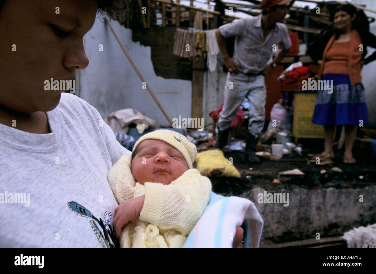 Earthquake in Colombia 1999  - A girl carries her new born sister while her family gathers what they can in Calarca Stock Photo