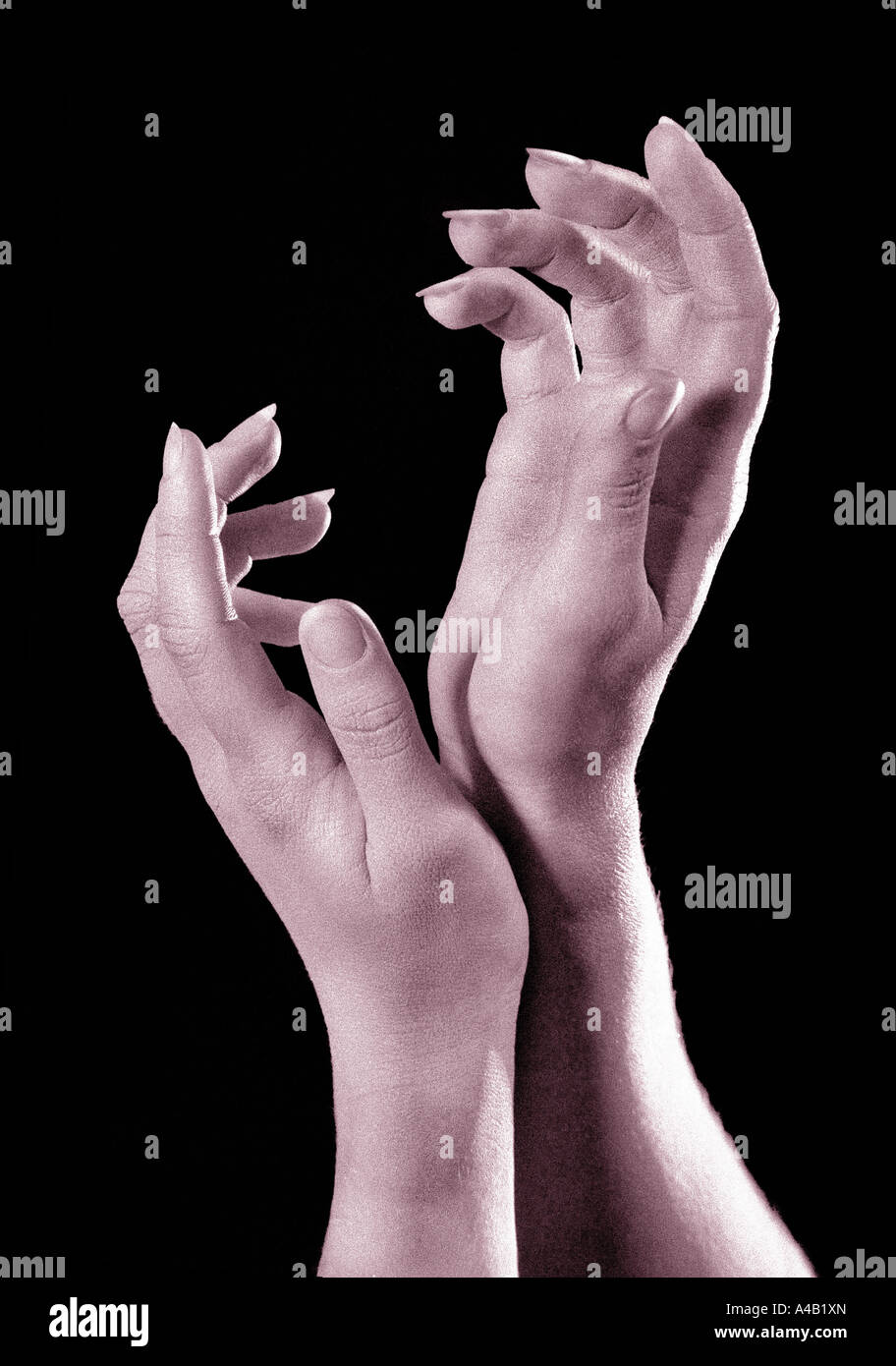 womans hands wrists touching fingertips reaching monochrome plain black