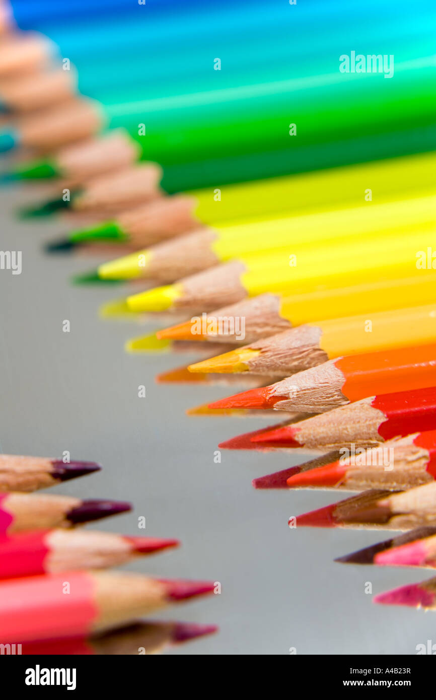 coloured pencils arranged in rows on a silver background Stock Photo