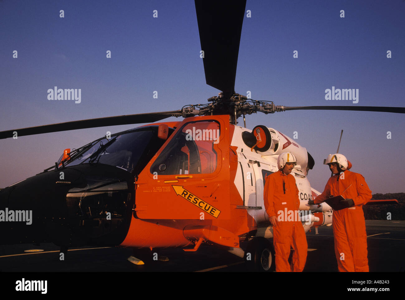 two Coast Guard helicopter pilots standing in front of Sikorsky Seahawk helicopter Stock Photo