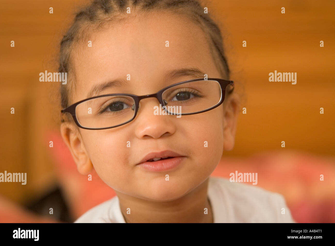 A beautiful young mixed race girl wearing slightly oversized glasses Stock Photo