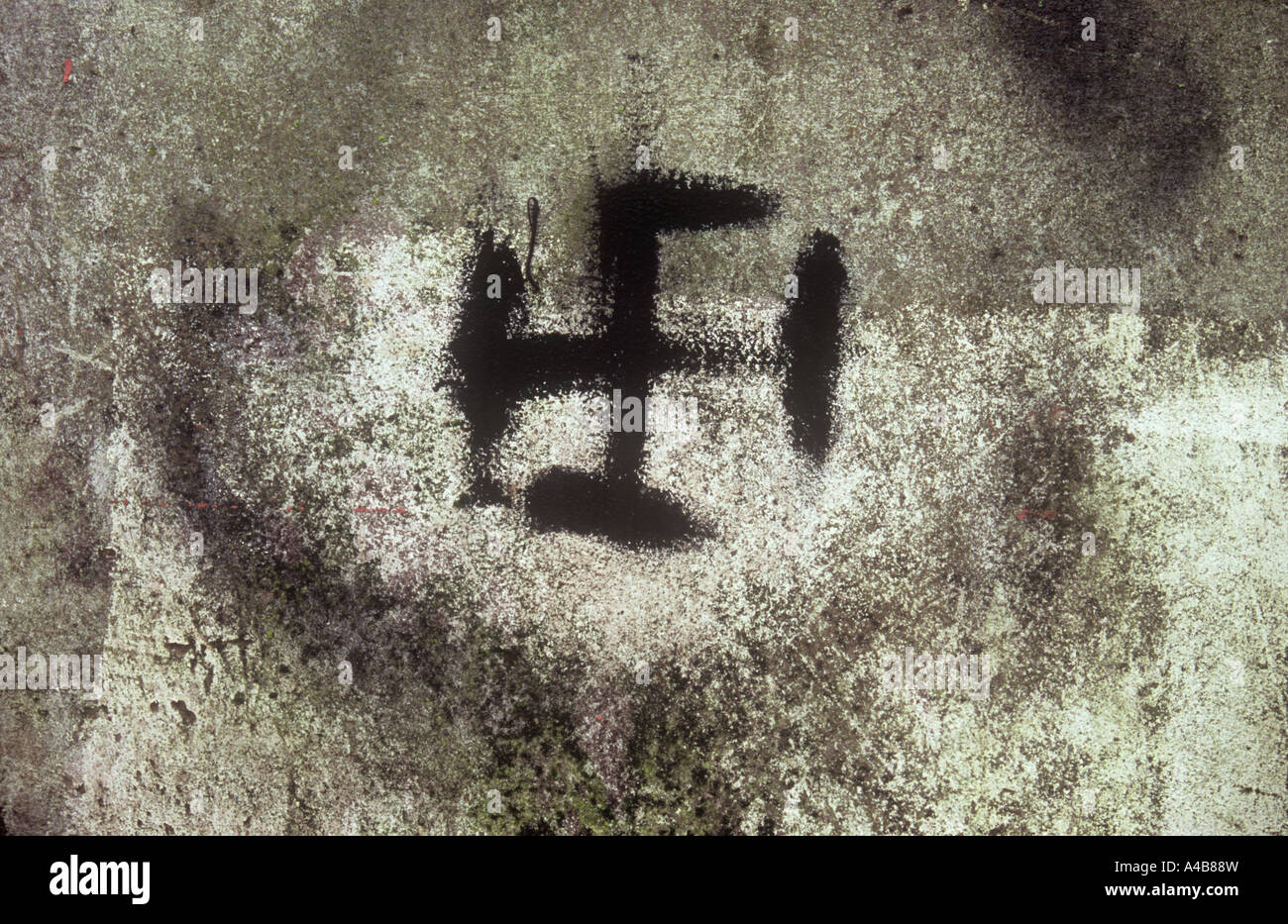 Close up of badly painted black swastika symbol on grubby stained cement or concrete Stock Photo