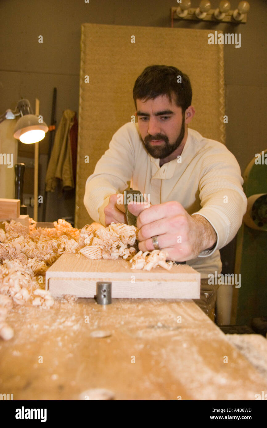 Furniture maker planing a board at his work bench Stock Photo Alamy
