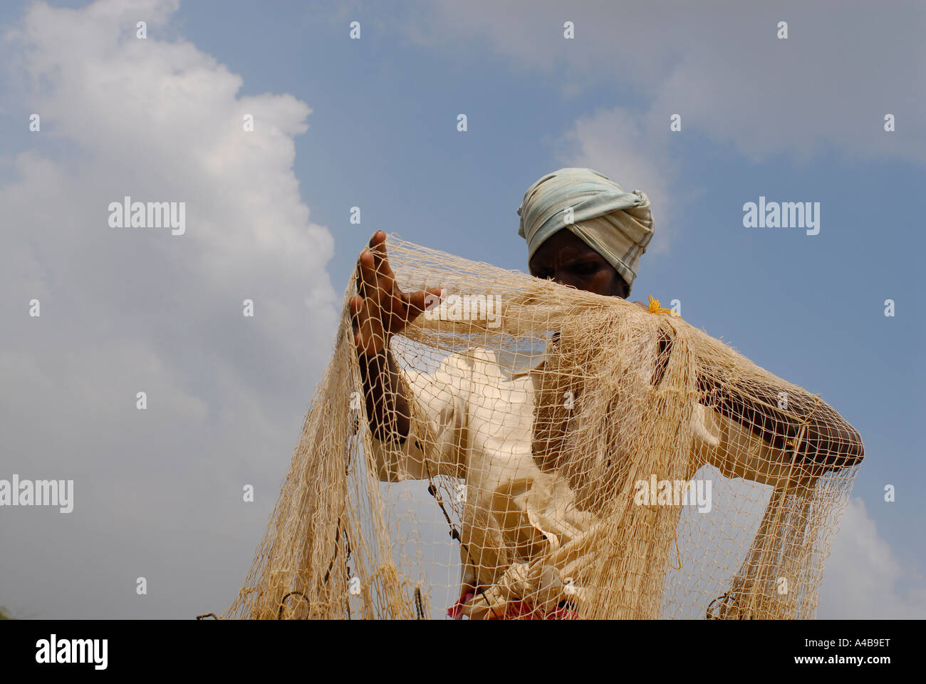 Stock image of Dalit tribal fisherman casting his net while wearing a turban Stock Photo