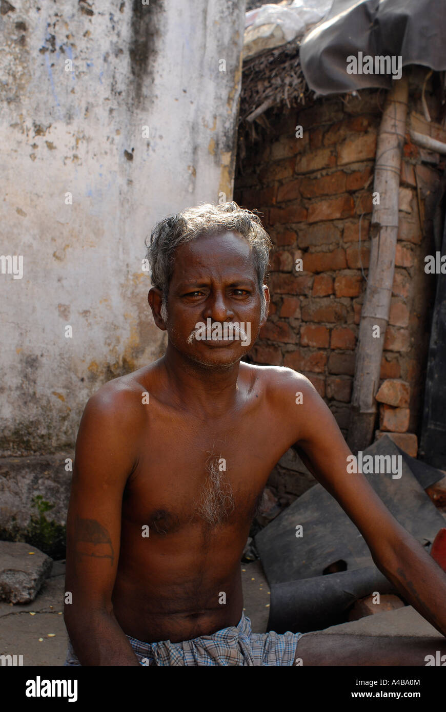 Stock Image of bare chested Dalit man in Jagathapuram slum in Chennai Tamil Nadu India Stock