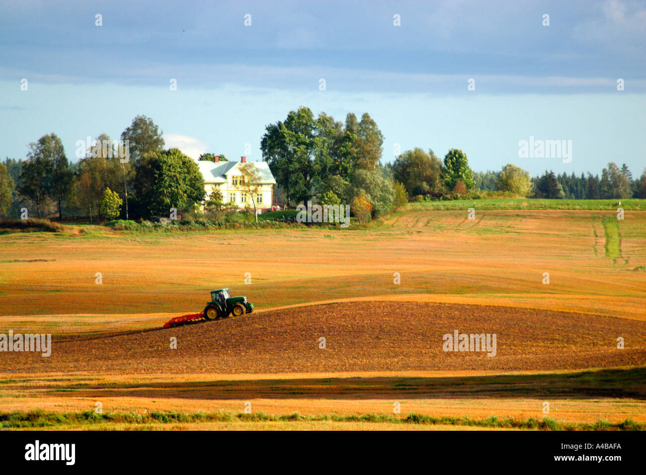 Field with a tractor Stock Photo - Alamy