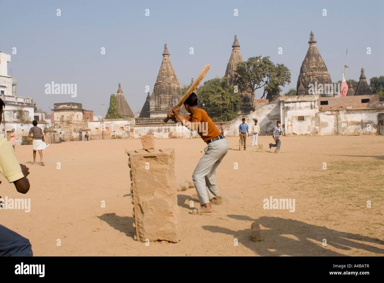 Stock image of young indian boys playing cricket on the temple grounds of a Shiva temple in Varanasi India Stock Photo