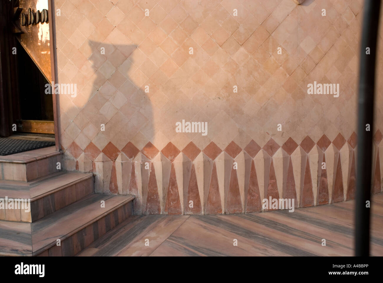 Stock image of a policeman s cap s shadow against a marble wall in Agra india Stock Photo