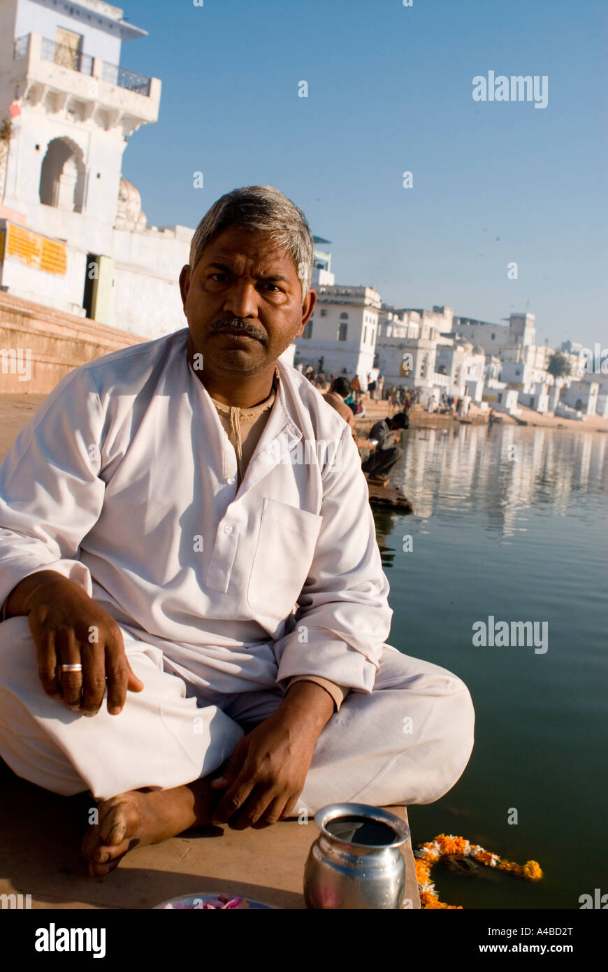 Stock image of Brahmin priest on the bathing ghats at the hindu holy city of Pushkar Rajasthan India making prayers and pooja Stock Photo