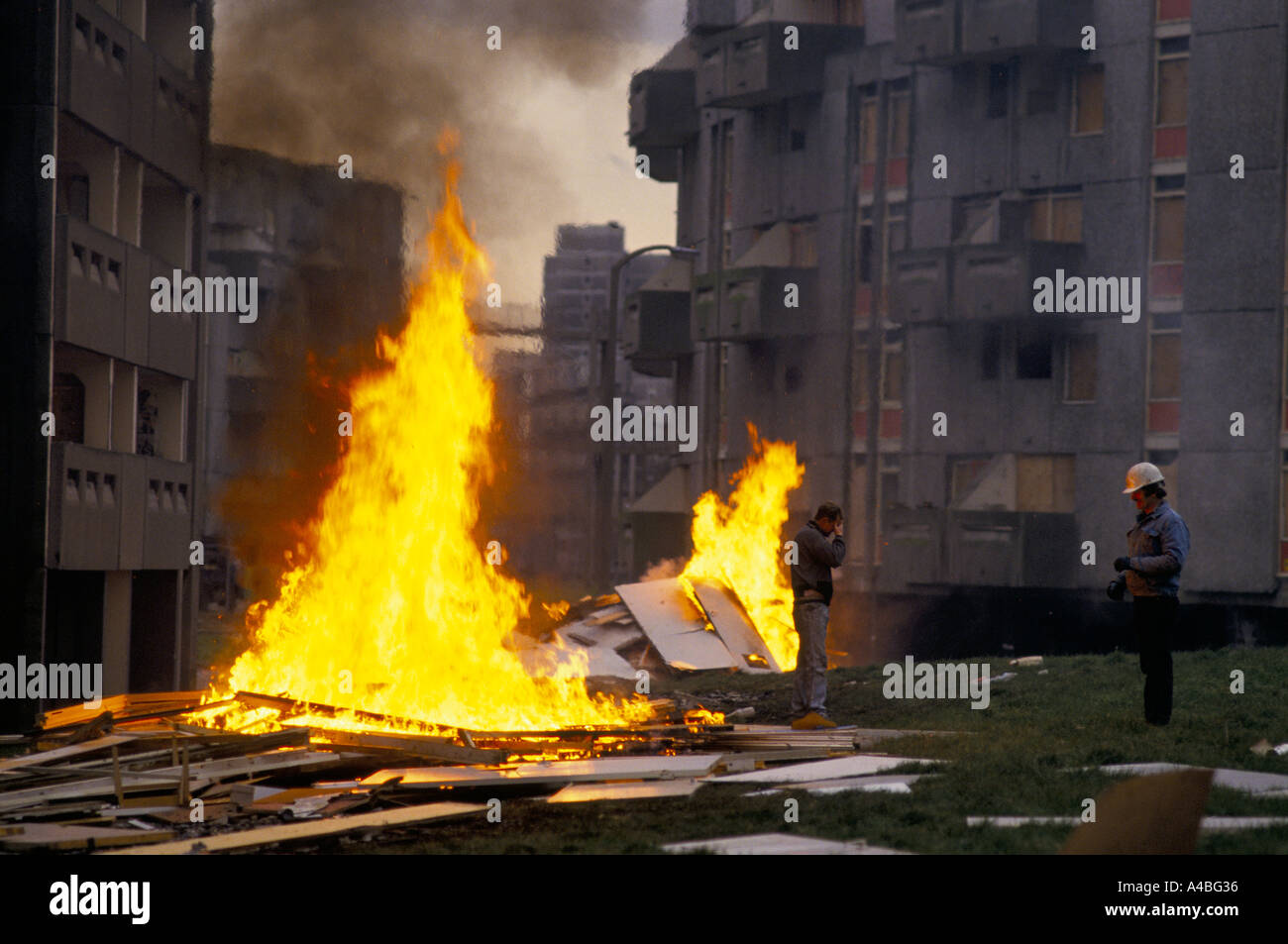 SCRAP PANELS BURNING IN HIGH FLAMES ON GROUND OF HUME CRESCENT. WORKERS OF DEMOLITION IN DESPAIR. HIGH RISE ESTATE. Stock Photo