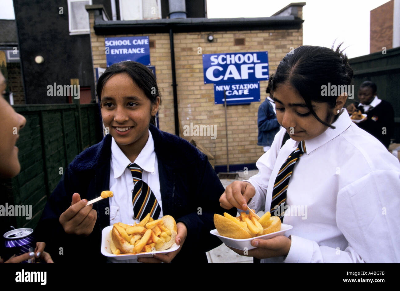 FOREST GATE, LONDON FOREST GATE COMPREHENSIVE SCHOOL, CHILDREN EATING AT A CHIP SHOP NEARBY THAT CALLS ITSELF 'SCHOOL CAFE', Stock Photo