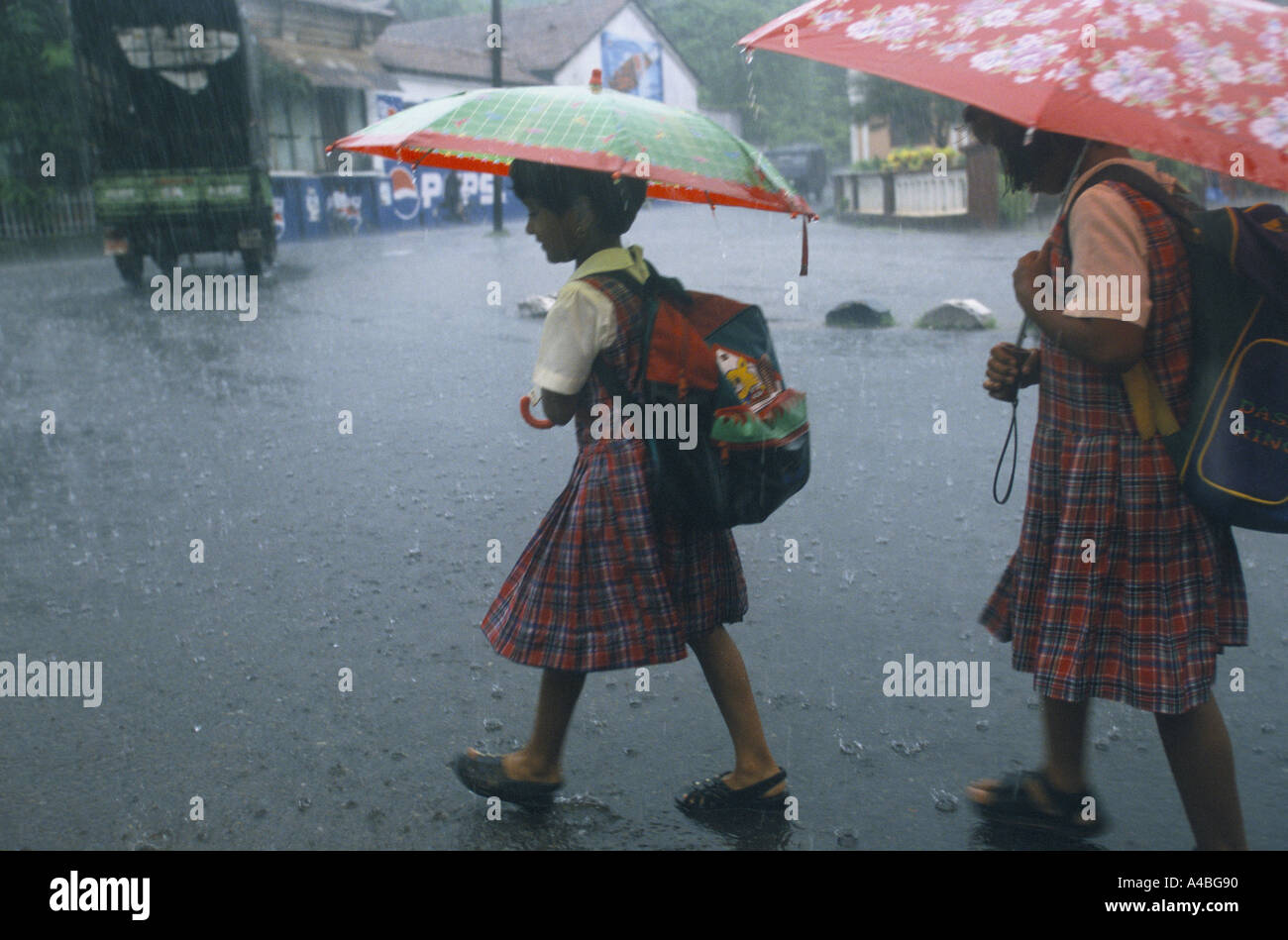 MONSOON STORY, INDIA', GOA. SCHOOL CHILDREN GOING HOME IN HEAVY RAIN IN THE MARKET TOWN OF MAPUSA, 1999 Stock Photo