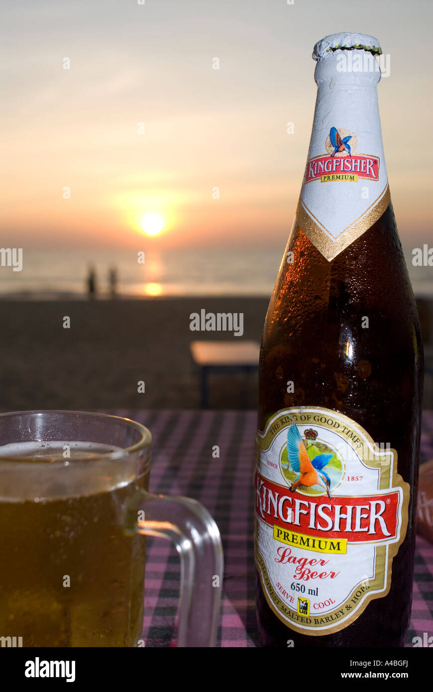 Stock image of Kingfisher Beer and glass at sunset in Goa Stock Photo