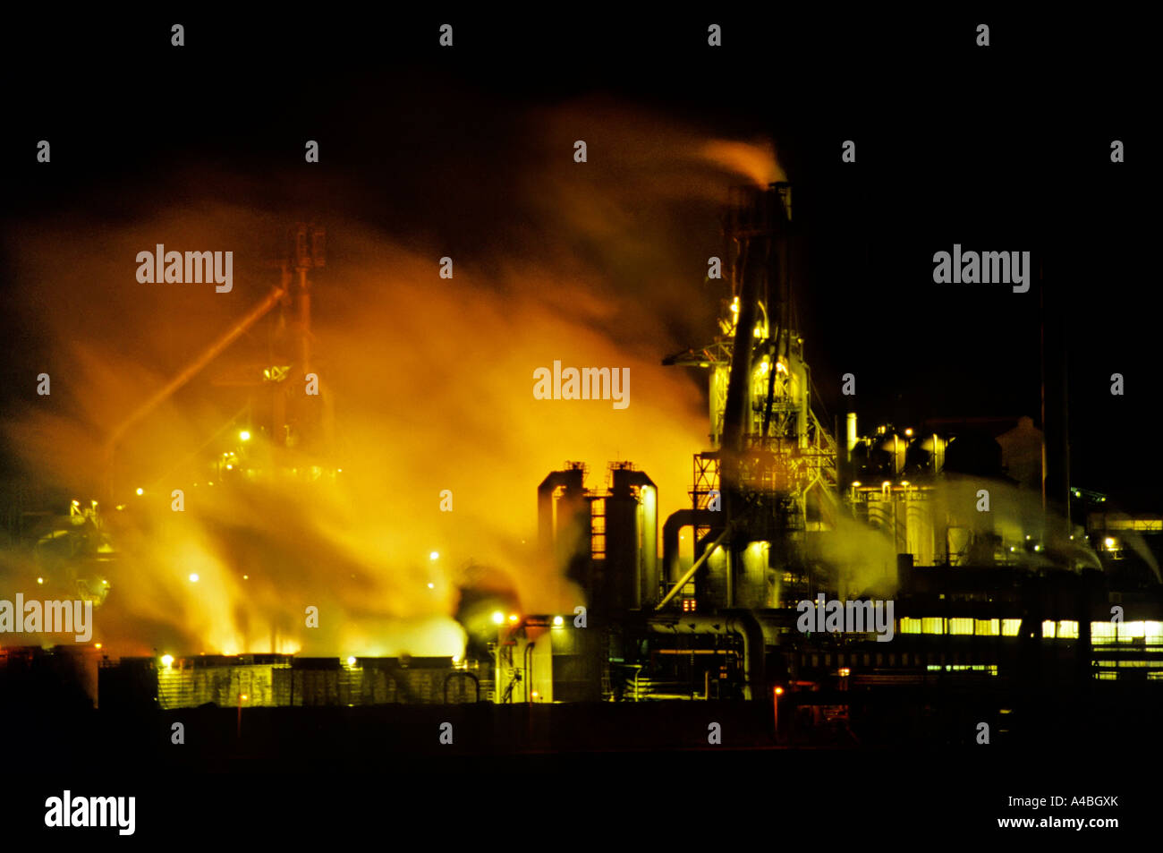 Smoke and fumes rising from floodlit steelworks Port Talbot Wales UK Stock Photo