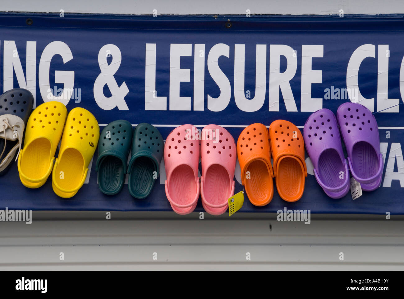 Colourful plastic shoes for sale at a ships chandlers Stock Photo