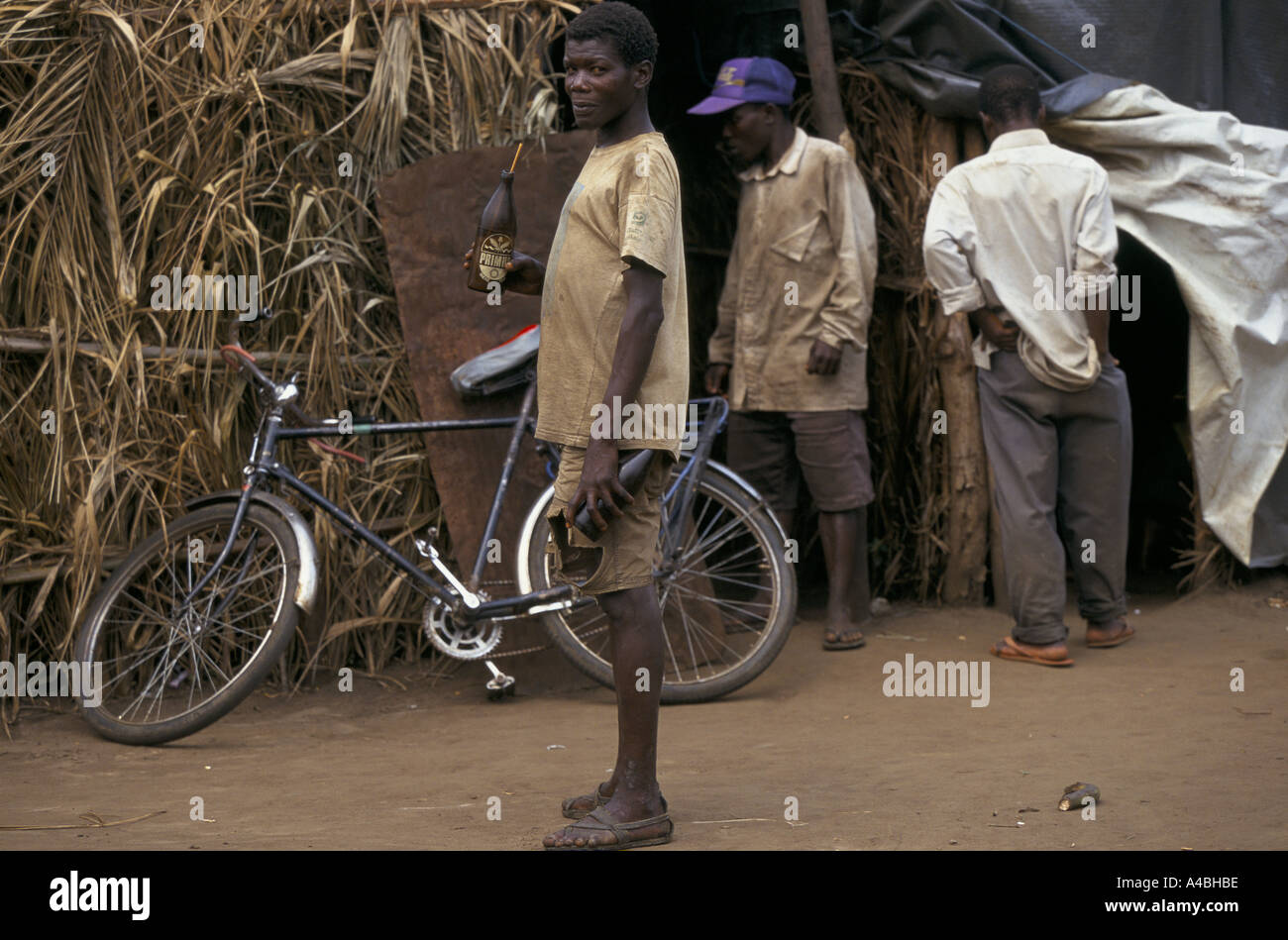 Burundi's regroupment camps, Jan 2000: Life in Ruberizi is tedious - this man is drinking homemade beer in the middle of the day Stock Photo