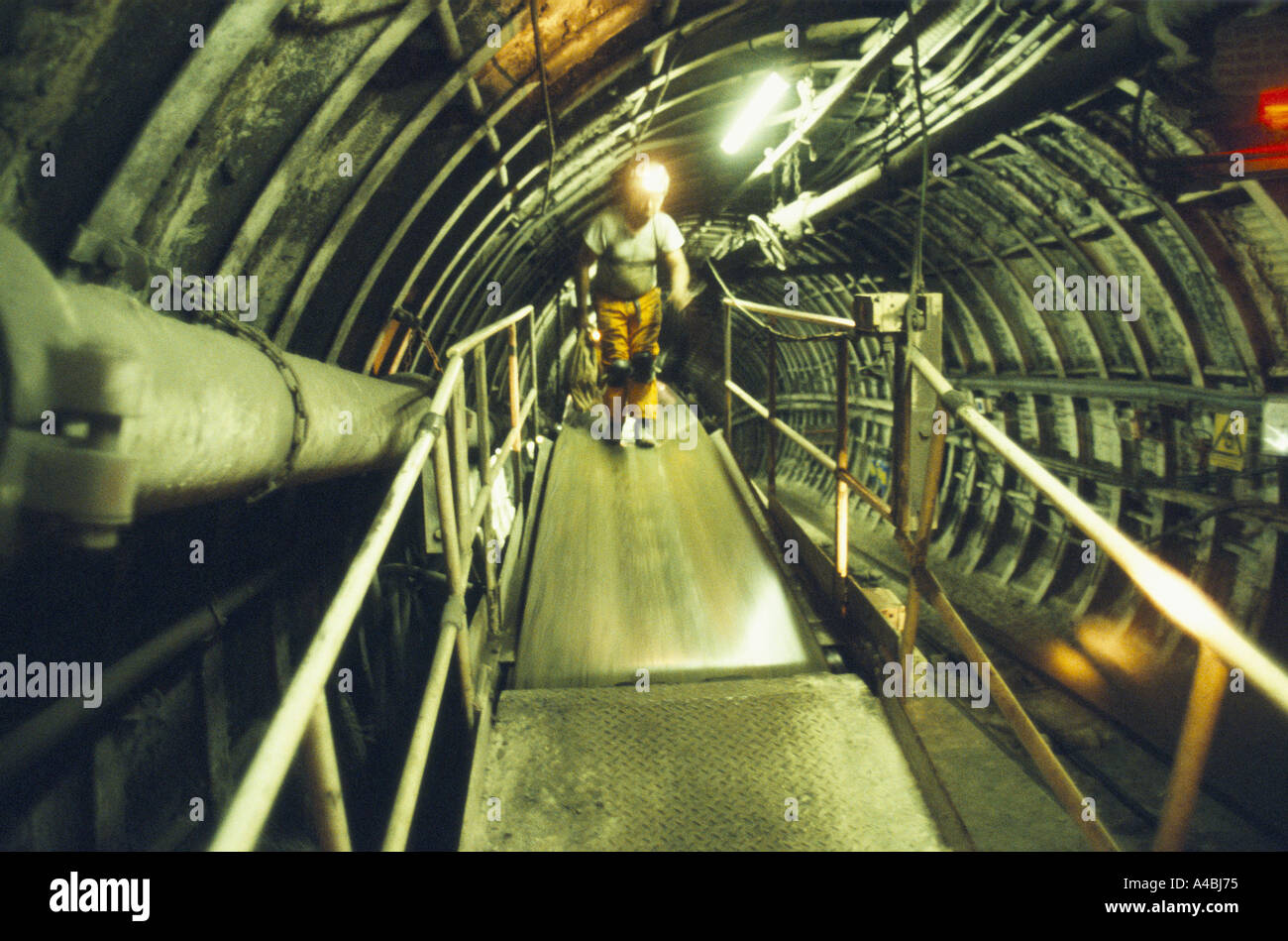 MINER WITH HEAD TORCH & SAFETY HELMET ON WALKWAY IN TUNNEL UNDERGROUND. SHIREBROOK COLLIERY, NOTTINGHAMSHIRE OCT 1992. Stock Photo
