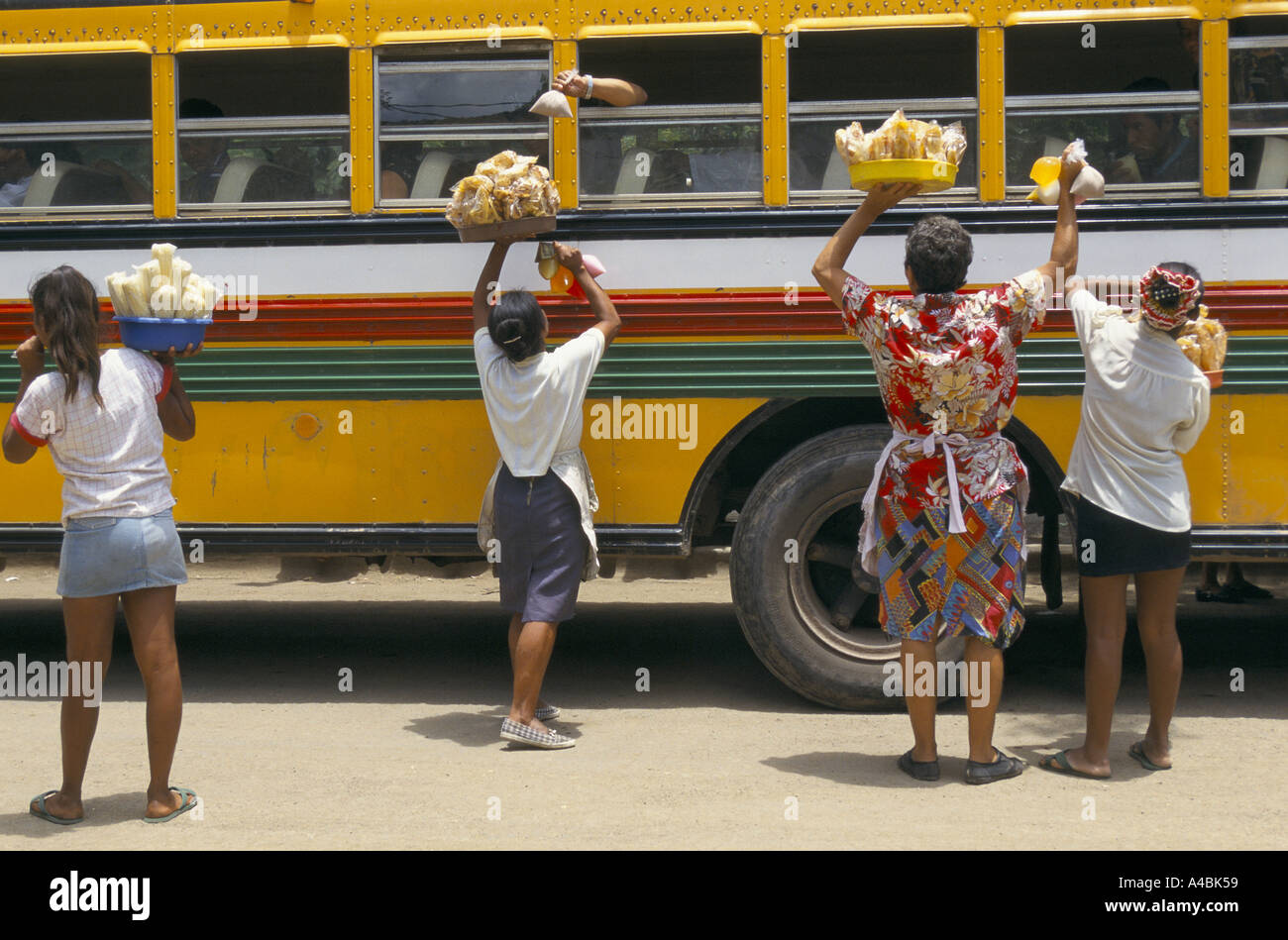Women selling food and drink to bus passengers in Condega. Stock Photo