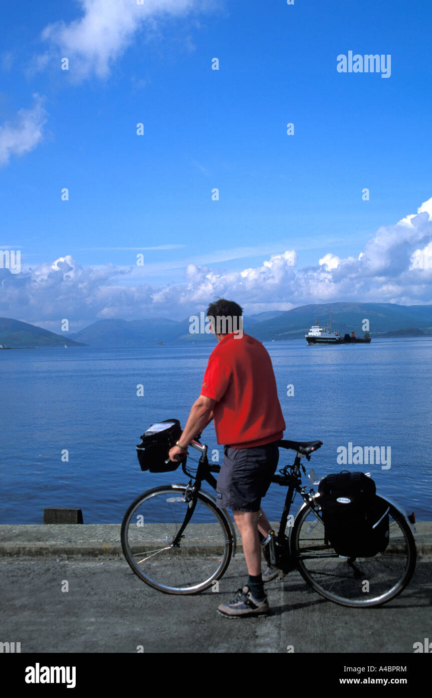 Biker watching the Caledonian Macbrayne ferry coming in to Rothesay harbour Isle of Bute Scotland Stock Photo