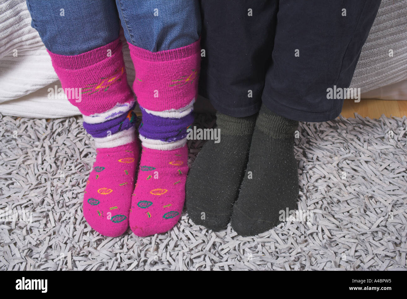 Couple sitting on sofa wearing socks Stock Photo