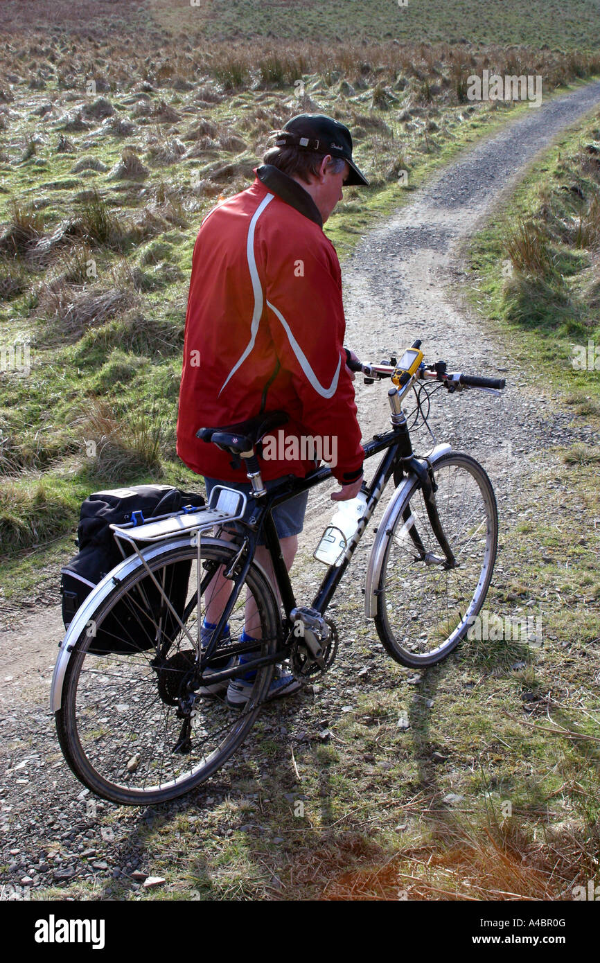 Cyclist using a GPS handheld navigation system attached to the
